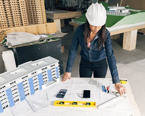 african-american-lady-safety-helmet-standing-near-model-building - 1