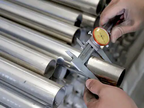 IQC inspector measuring stainless steel tube dimensions with caliper in faucet factory