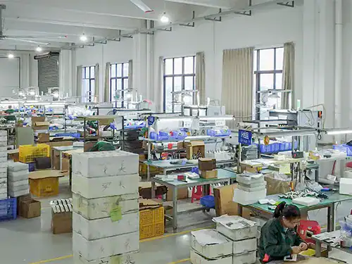 Fachkundige Techniker montieren OEM-Edelstahlarmaturen an einer zellenbasierten Produktionslinie.